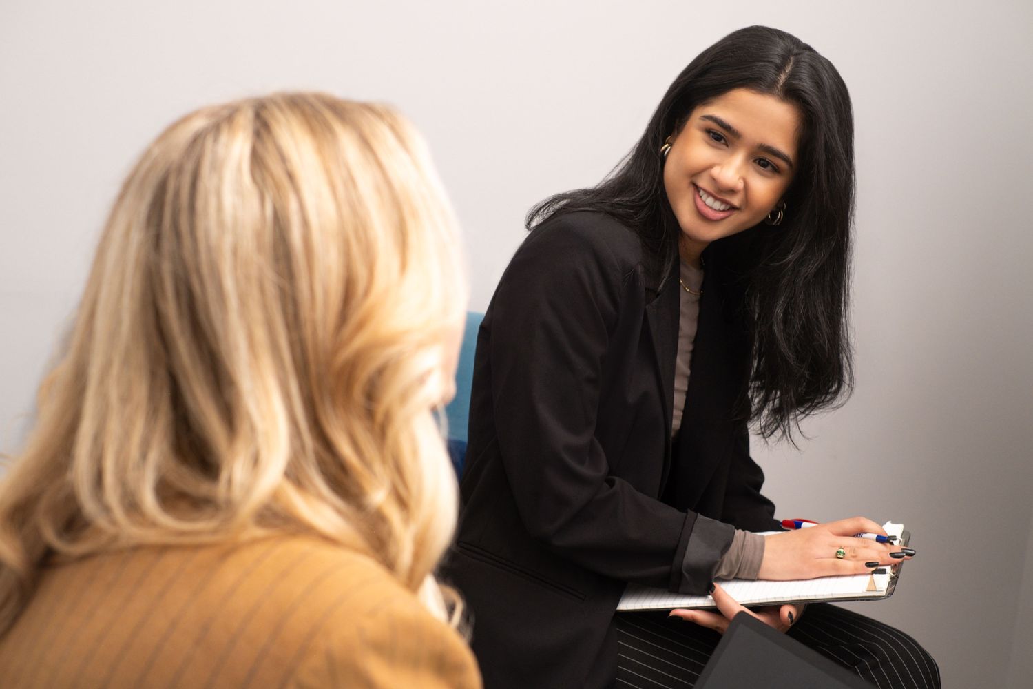 Anha Jhuremalani in session with a client, smiling and taking notes