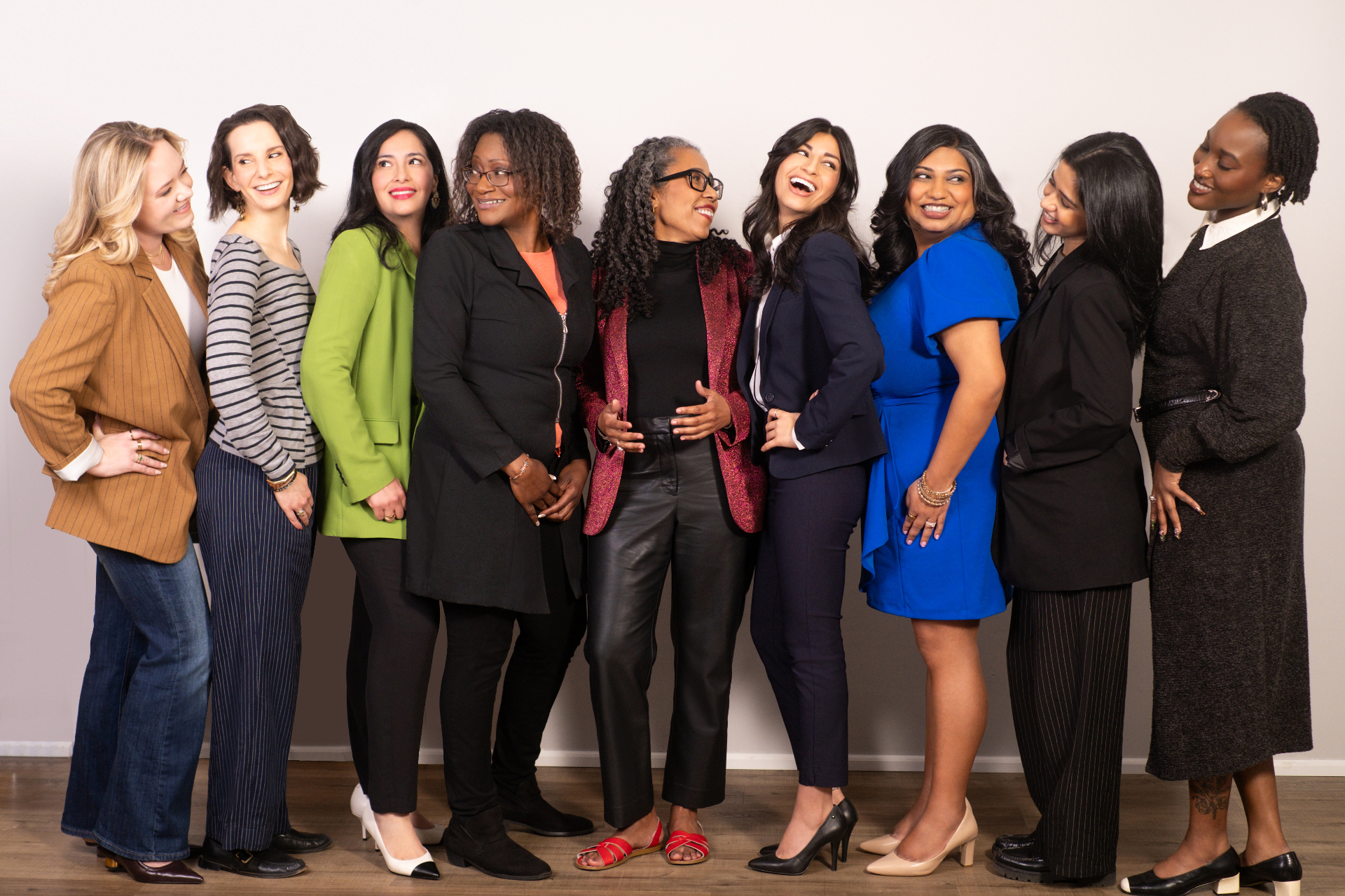 A group of women clinicians and colleagues standing together, smiling